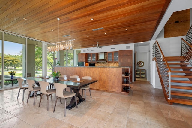 dining space with a notable chandelier, wood ceiling, and expansive windows