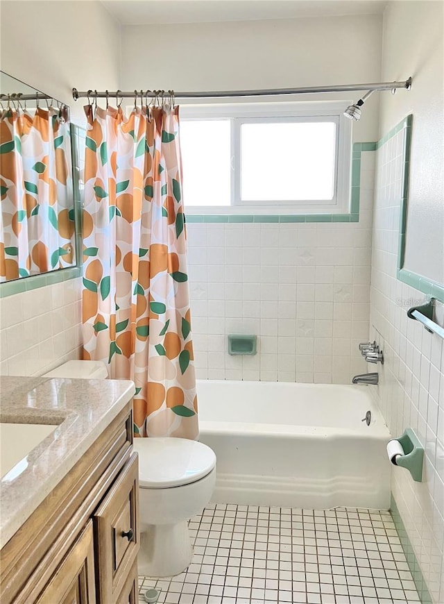 full bathroom with shower / tub combo with curtain, toilet, tile walls, vanity, and tile patterned flooring