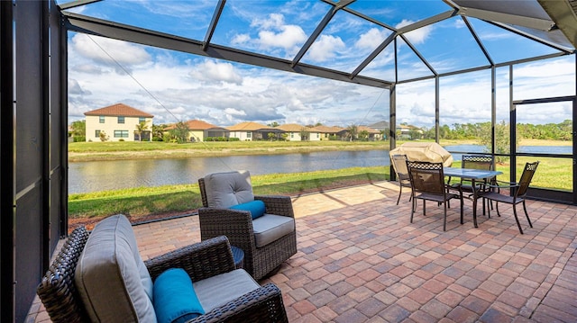 view of patio / terrace with a water view and glass enclosure