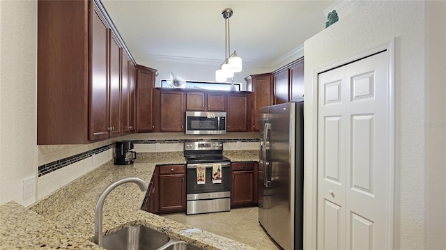 kitchen featuring sink, crown molding, appliances with stainless steel finishes, pendant lighting, and light stone countertops