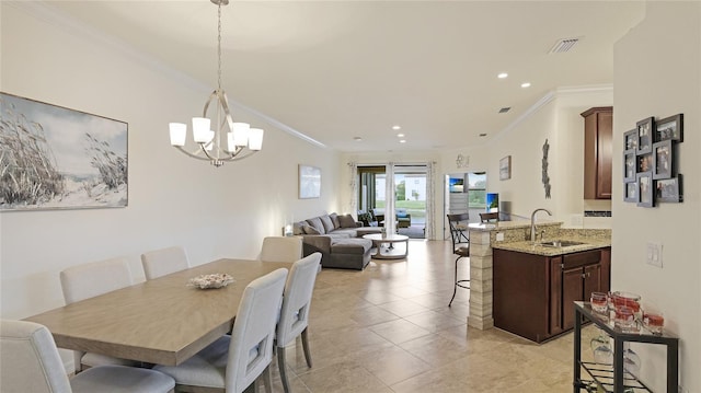 tiled dining room featuring sink, crown molding, and a chandelier