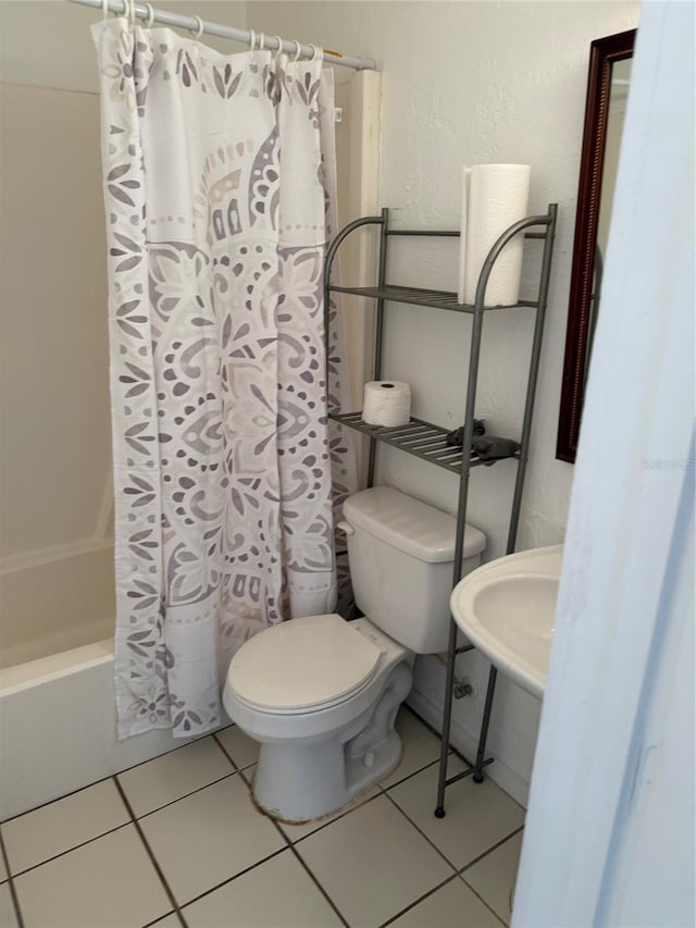 bathroom featuring tile patterned flooring, toilet, and shower / bath combo with shower curtain