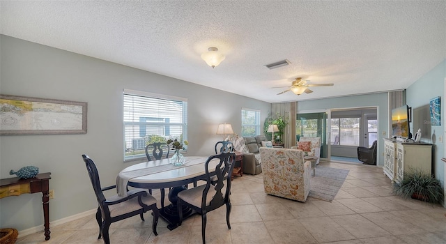 tiled dining room featuring a textured ceiling and ceiling fan