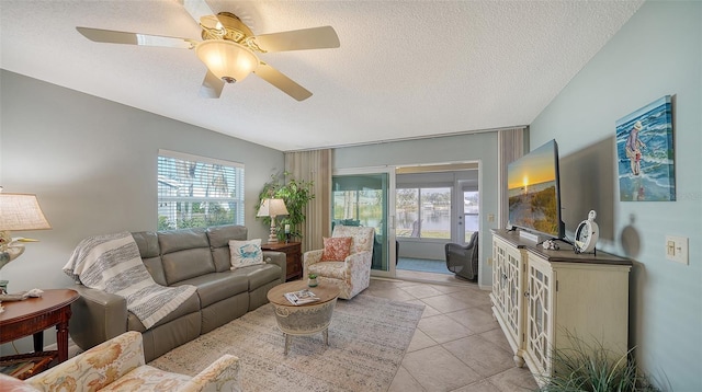 tiled living room with ceiling fan, a healthy amount of sunlight, and a textured ceiling