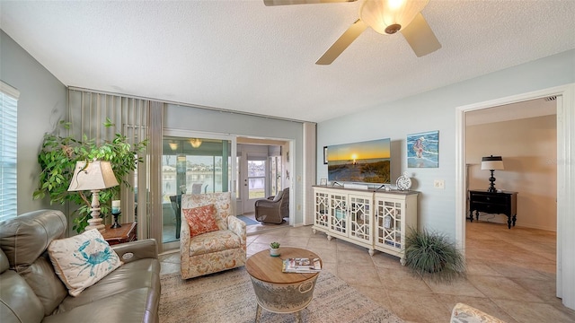 tiled living room featuring ceiling fan and a textured ceiling