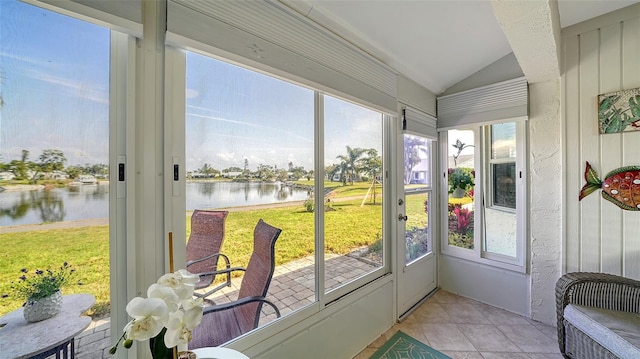 sunroom / solarium featuring lofted ceiling and a water view