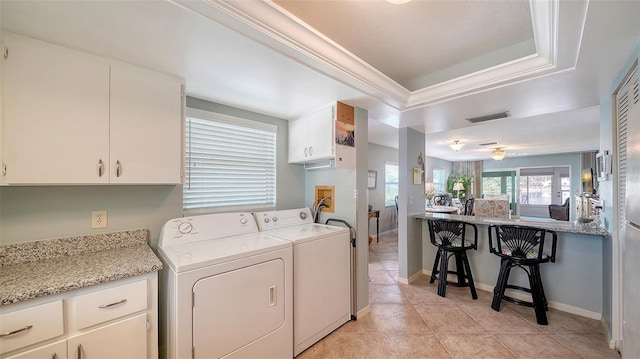 laundry room featuring light tile patterned flooring, cabinets, ornamental molding, and washer and dryer