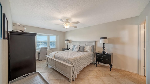 tiled bedroom with ceiling fan and a textured ceiling