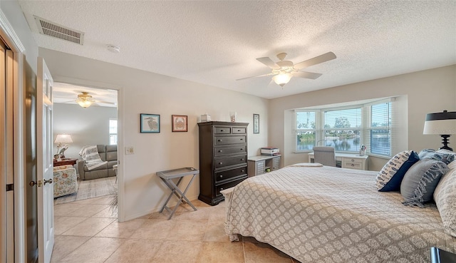 tiled bedroom featuring a textured ceiling and ceiling fan