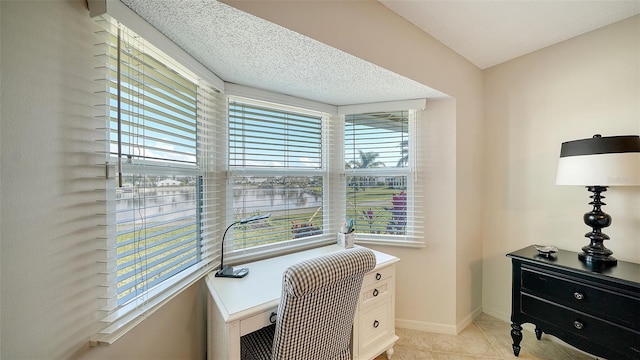 office with light tile patterned floors and a healthy amount of sunlight