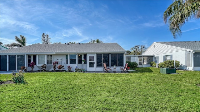 rear view of property with a yard and a sunroom