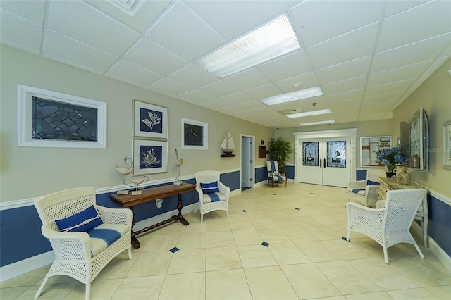 living area with a paneled ceiling