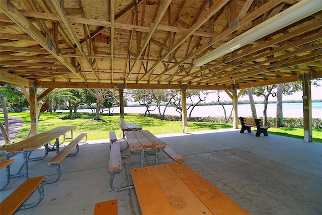 view of property's community featuring a water view, a patio, and a lawn