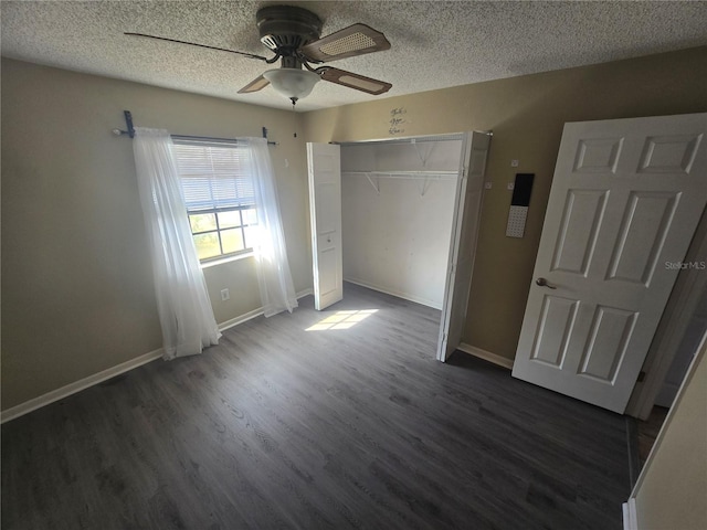 unfurnished bedroom with ceiling fan, dark hardwood / wood-style floors, a textured ceiling, and a closet