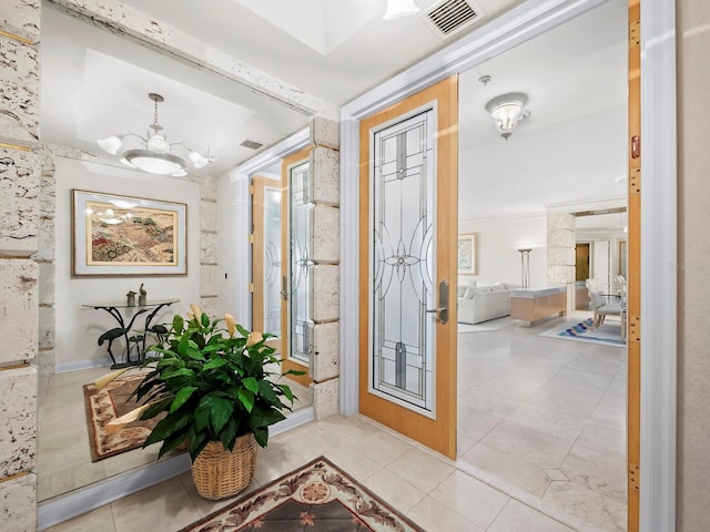 tiled foyer entrance featuring a chandelier