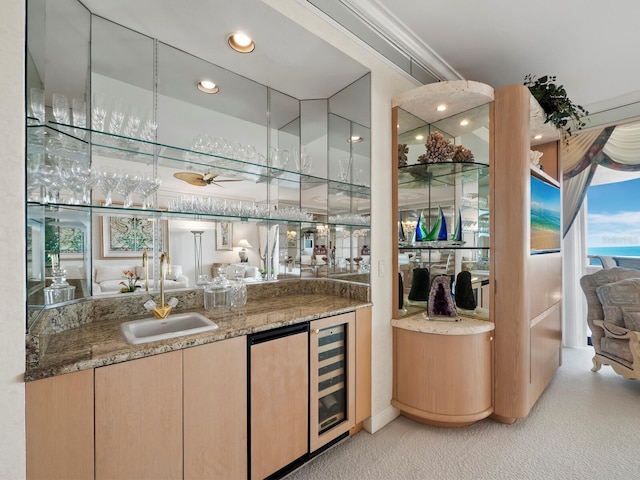 bar with sink, refrigerator, stone countertops, light colored carpet, and beverage cooler