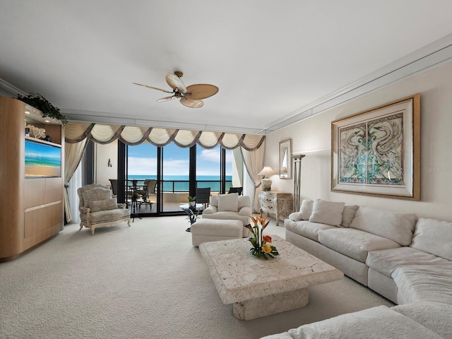 living room with floor to ceiling windows, a water view, carpet floors, and ceiling fan