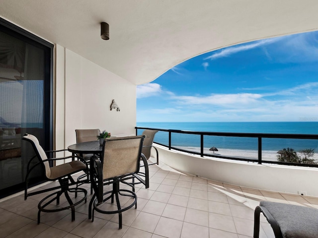 balcony featuring a beach view and a water view