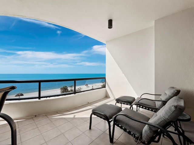 balcony featuring a water view and a view of the beach