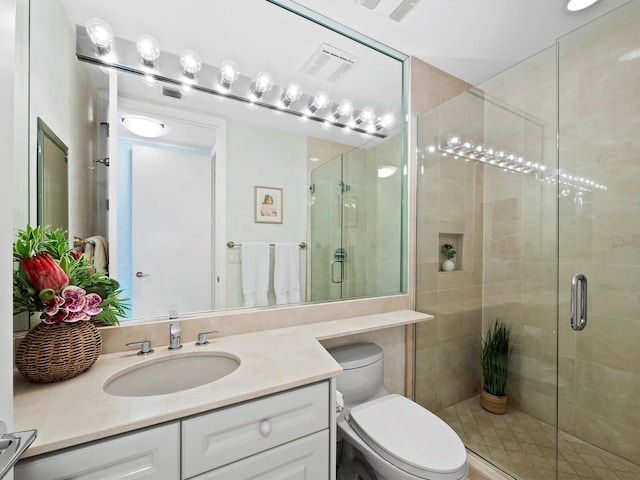 bathroom with a shower with door, vanity, and toilet