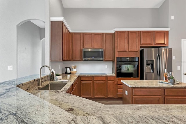 kitchen featuring sink, light stone counters, and black appliances