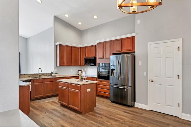 kitchen featuring a kitchen island, appliances with stainless steel finishes, high vaulted ceiling, sink, and hardwood / wood-style flooring