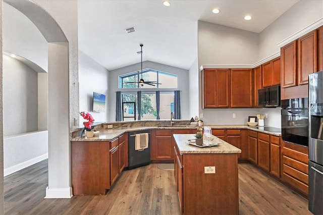 kitchen featuring sink, decorative light fixtures, a center island, appliances with stainless steel finishes, and kitchen peninsula