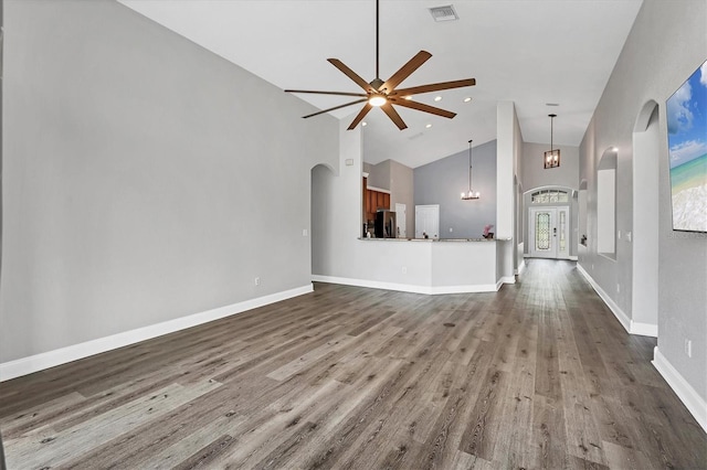 unfurnished living room with hardwood / wood-style floors, high vaulted ceiling, and ceiling fan