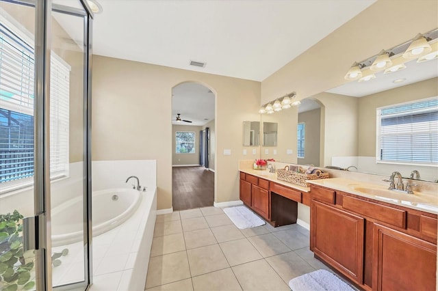 bathroom with ceiling fan, vanity, tiled bath, and tile patterned flooring