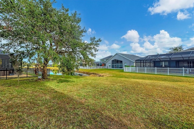 view of yard featuring glass enclosure and a water view