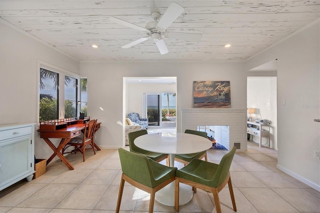 tiled dining space featuring wood ceiling, ceiling fan, and a fireplace