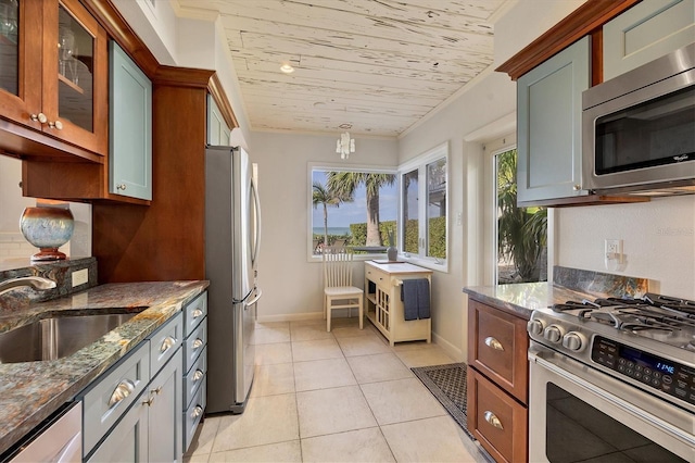 kitchen featuring sink, light tile patterned floors, appliances with stainless steel finishes, wooden ceiling, and dark stone counters