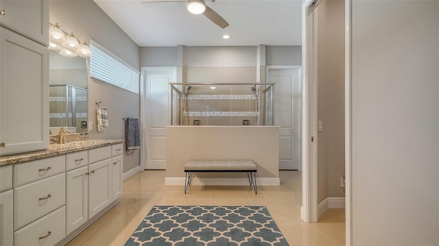 bathroom featuring a shower with door, vanity, tile patterned flooring, and ceiling fan