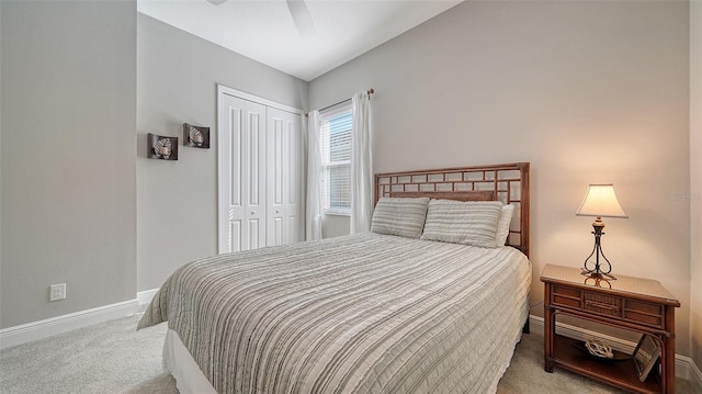 bedroom featuring light colored carpet, a closet, and ceiling fan