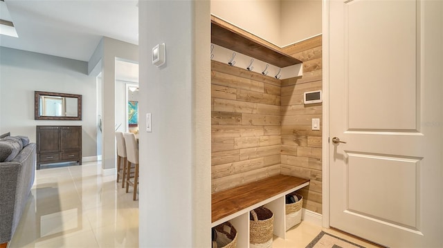 mudroom featuring wooden walls