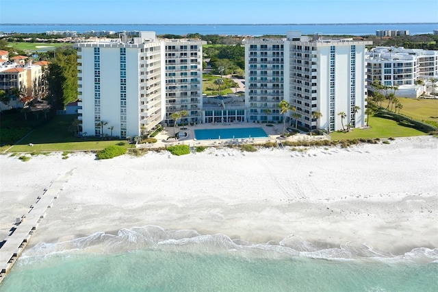 birds eye view of property featuring a water view and a beach view