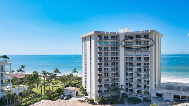 view of property with a water view and a beach view