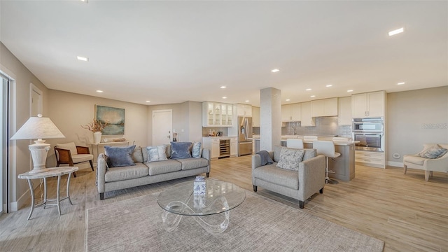 living room with beverage cooler and light hardwood / wood-style floors