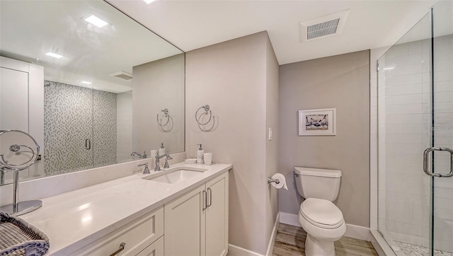 bathroom with vanity, toilet, a shower with shower door, and wood-type flooring