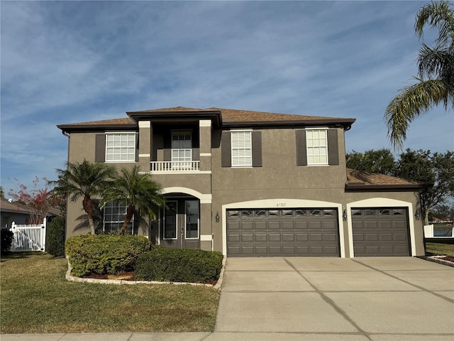 view of front of home featuring a balcony, a garage, and a front yard