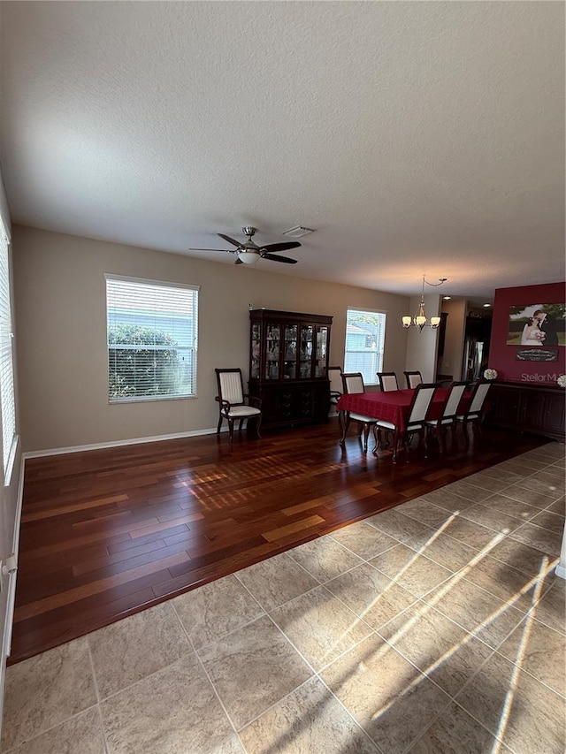 interior space featuring hardwood / wood-style flooring, ceiling fan with notable chandelier, and a textured ceiling