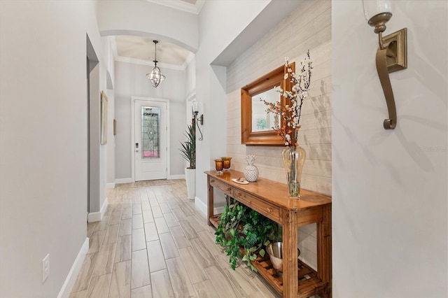 entrance foyer with ornamental molding and a notable chandelier