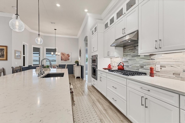 kitchen with hanging light fixtures, sink, a breakfast bar area, and white cabinets