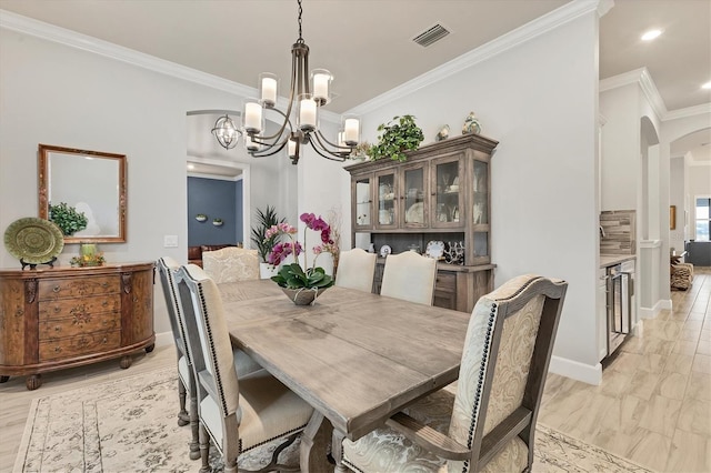 dining space featuring crown molding, a chandelier, light hardwood / wood-style flooring, and wine cooler