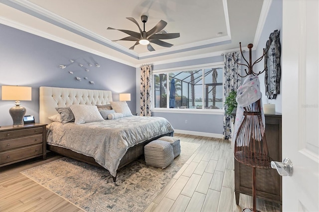 bedroom featuring a raised ceiling, crown molding, hardwood / wood-style flooring, and ceiling fan