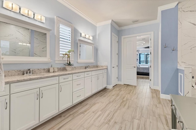 bathroom with crown molding, plenty of natural light, hardwood / wood-style floors, and vanity