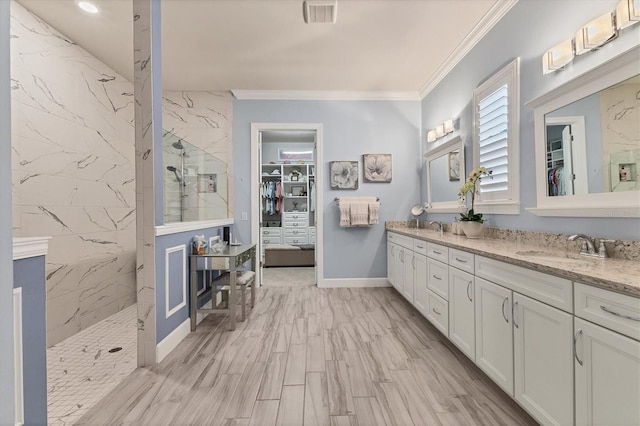 bathroom with tiled shower, ornamental molding, wood-type flooring, and vanity