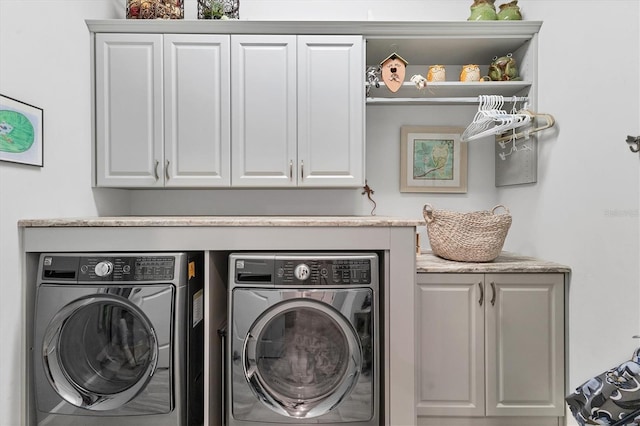 laundry room featuring cabinets and washer and dryer