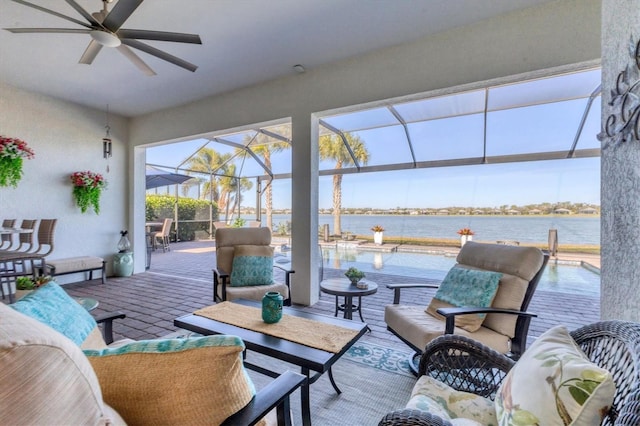 view of patio featuring a lanai, an outdoor hangout area, ceiling fan, and a water view