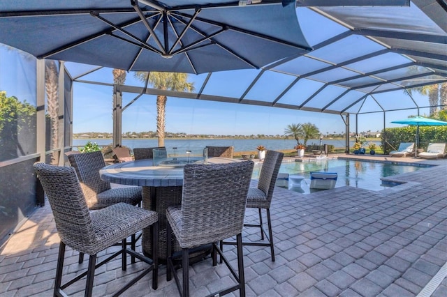 view of patio with a water view, a lanai, and pool water feature